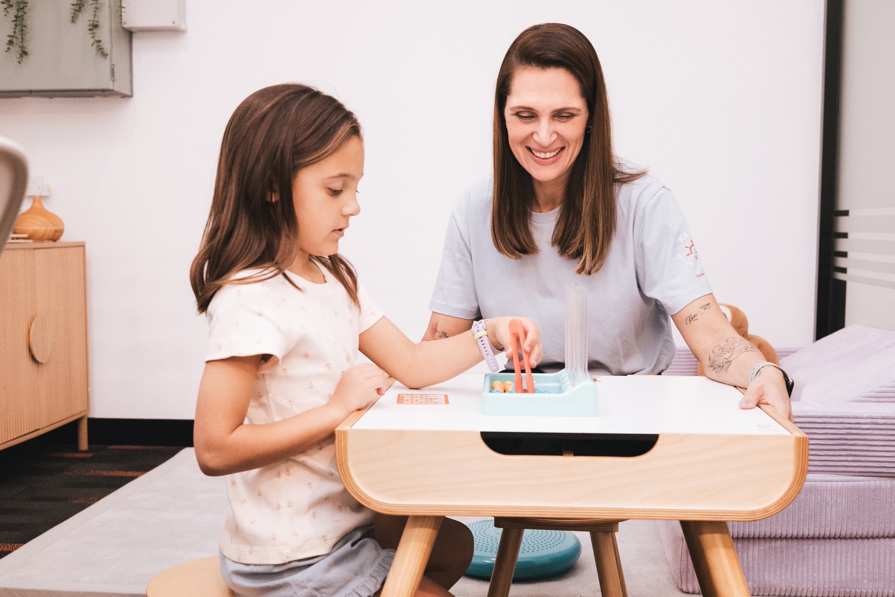 Amanda and a child working on a fine motor tool activity