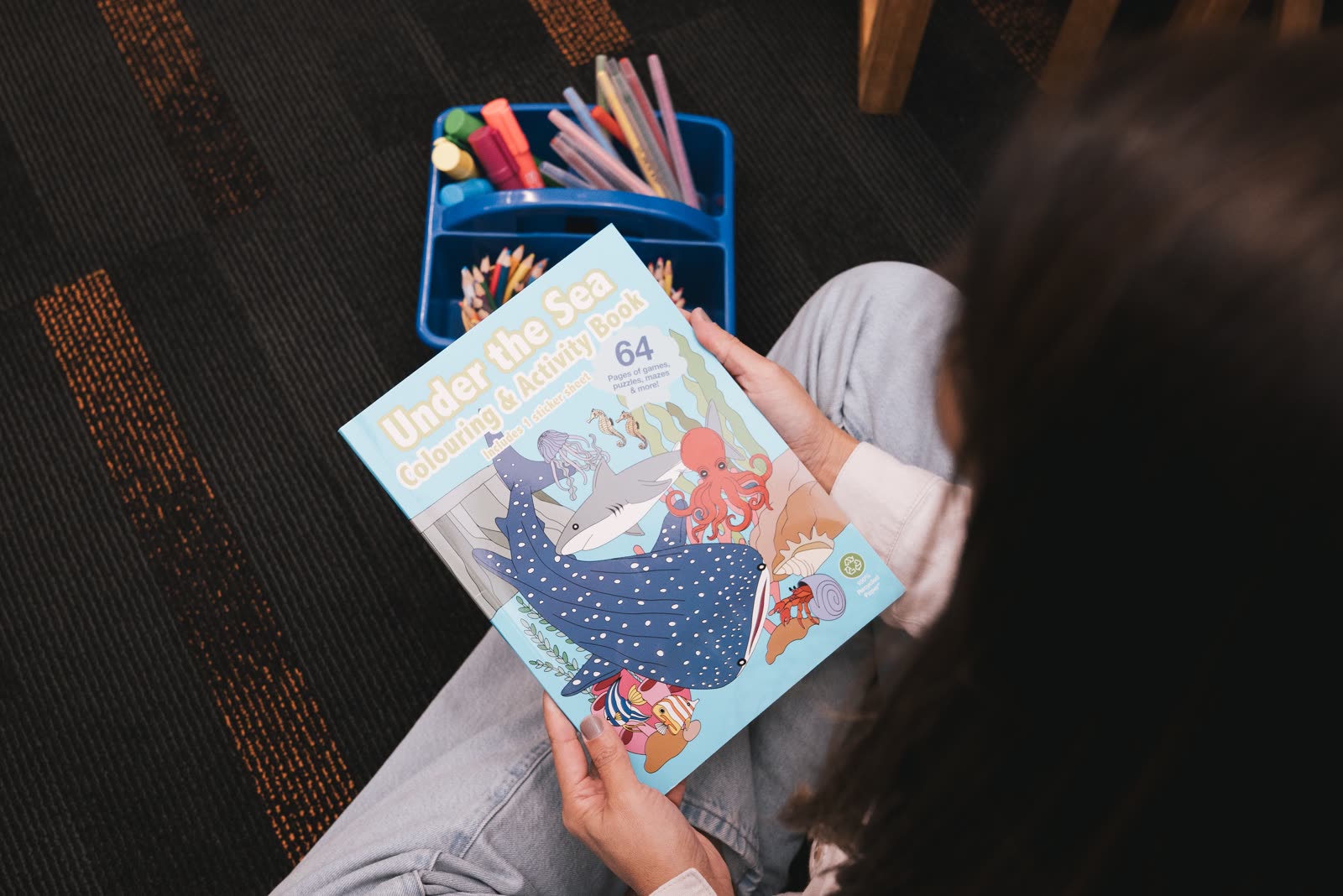 A child holding an Under the Sea colouring and activity book