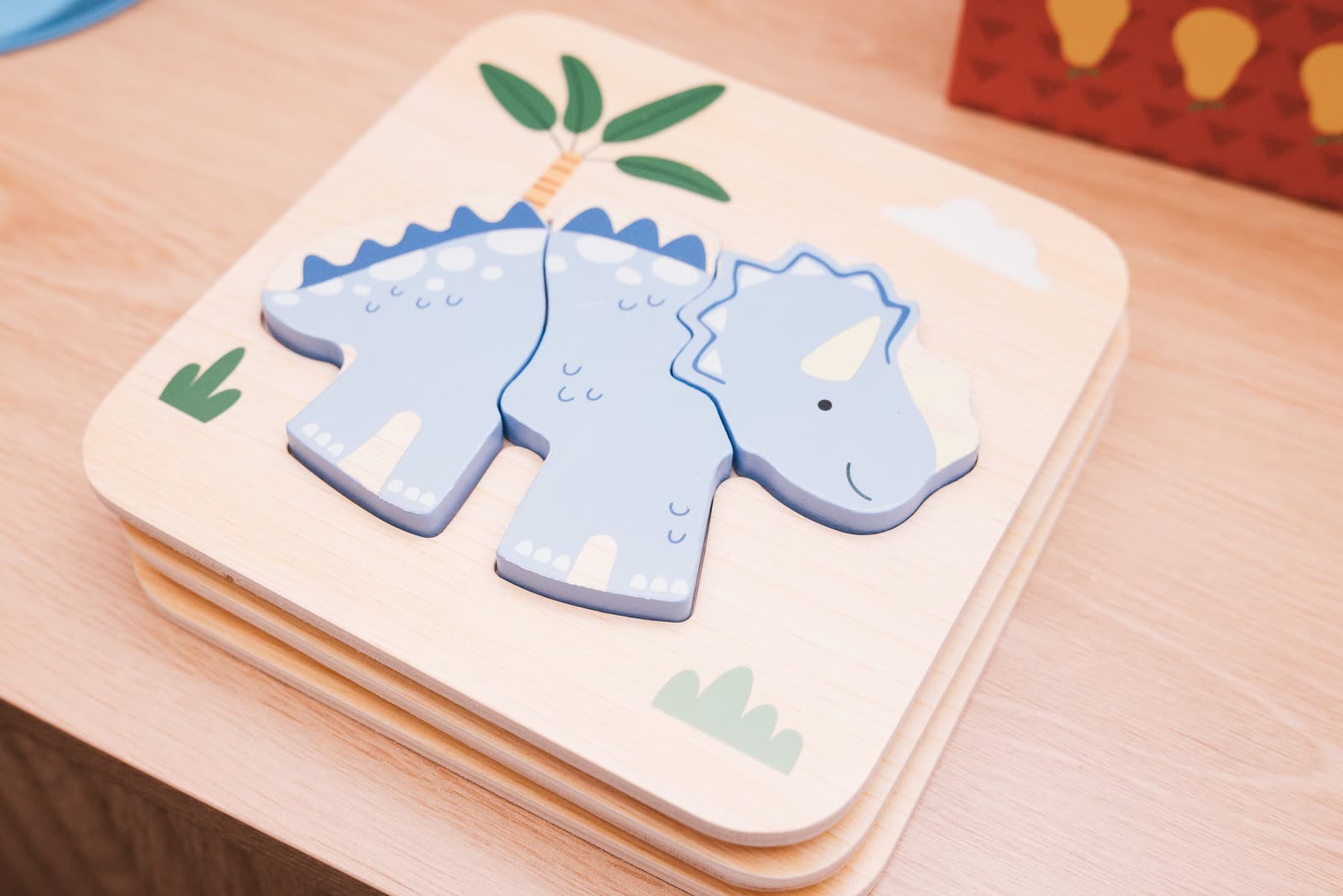 A wooden dinosaur puzzle on the therapy table