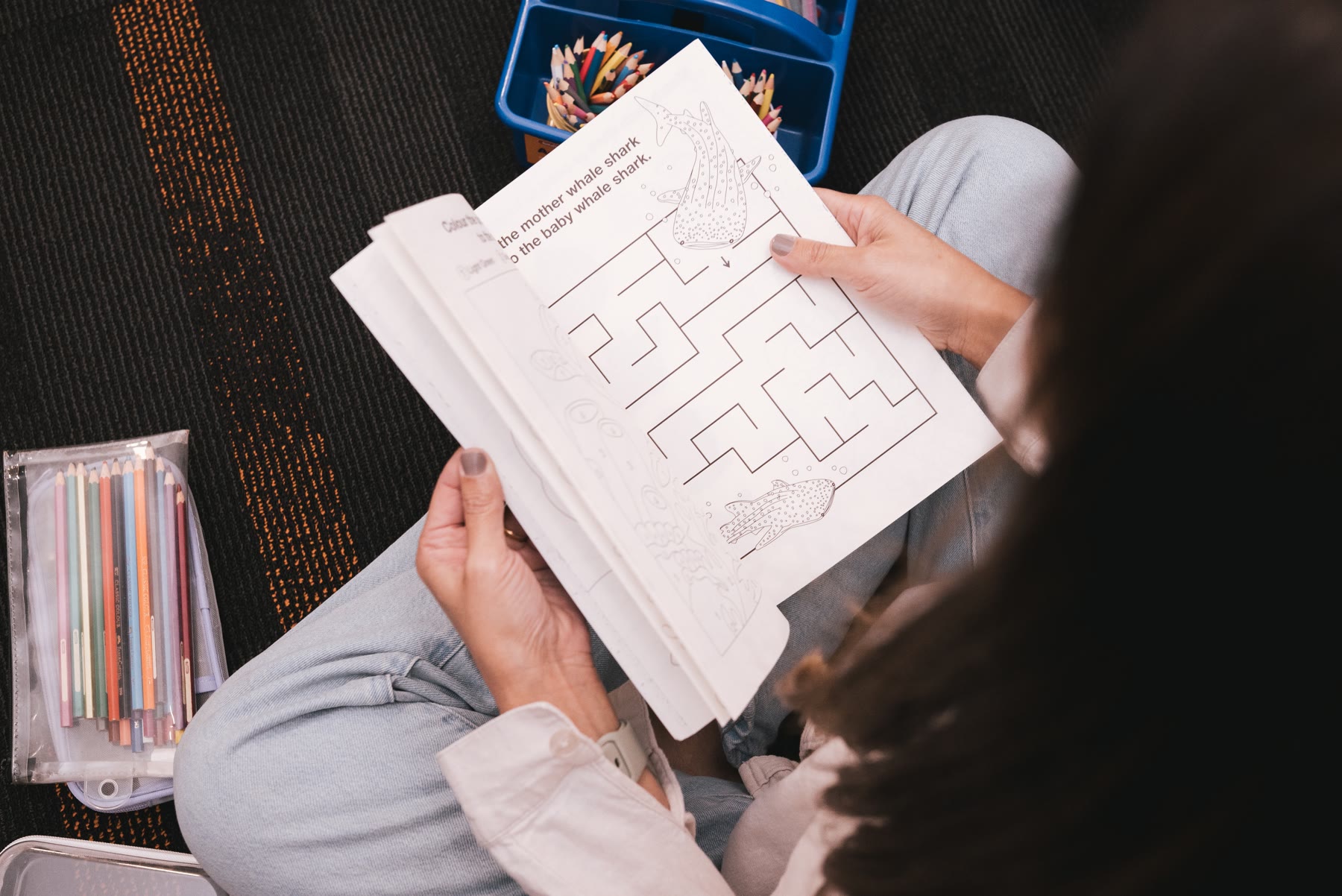 A child working through a maze activity book during a session